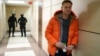 RUSSIA -- Russian opposition leader Aleksei Navalny stands near law enforcement agents in a hallway of a business centre, which houses the office of his Anti-Corruption Foundation (FBK), in Moscow, December 26, 2019