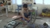 Tajikistan -- a man repairs a wheel cheer