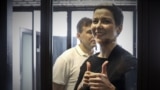 BELARUS -- Belarusian opposition activists Maryya Kalesnikava, foreground, and Maksim Znak, behind her, attend a court hearing in Minsk, August 4, 2021